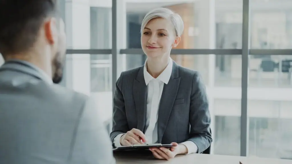 Confident female Human Resource Manager interviewing candidate in a modern office. Ideal for business and HR visuals.